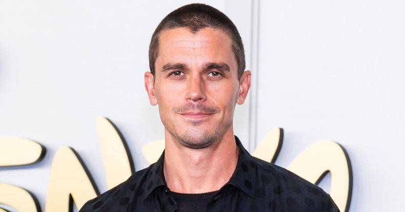 Antoni Porowski with a shaved head and black top and jacket.