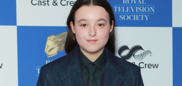 Bella Ramsey poses for a photo in a blue suit.