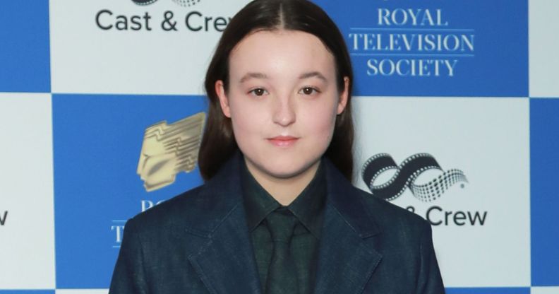 Bella Ramsey poses for a photo in a blue suit.