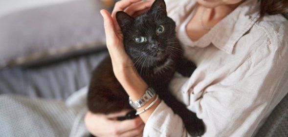 a woman holding a black cat