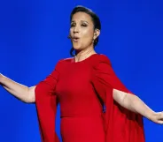Eurovision Song Contest host Petra Mede in a red dress singing.