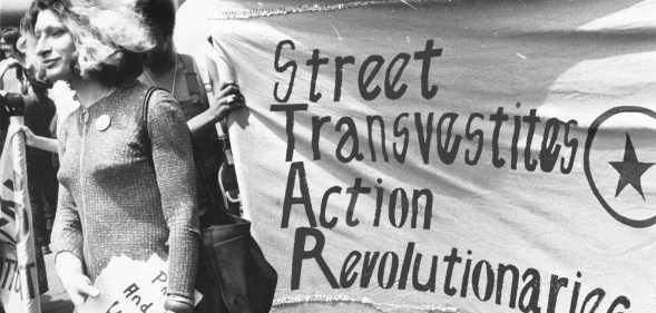Sylvia Rivera with a Street Transvestite Action Revolutionaries banner.