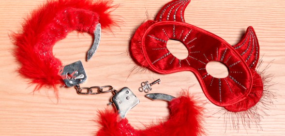 Fetish gear including furry red handcuffs and a devil mask