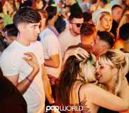 man looking on as two women kiss in popworld