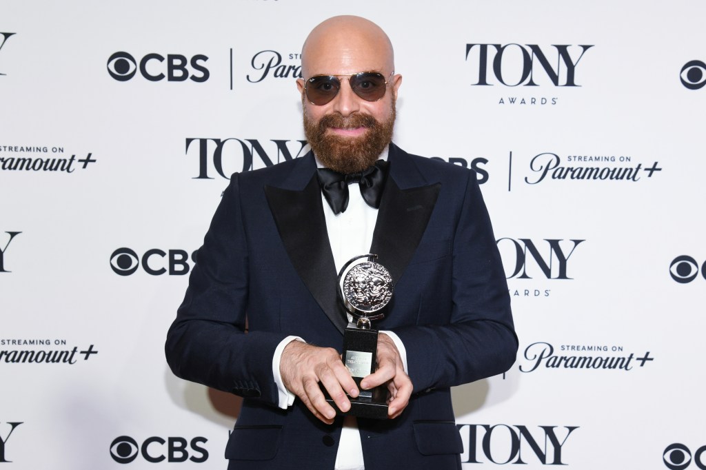 David Adjmi posing with his Tony Award
