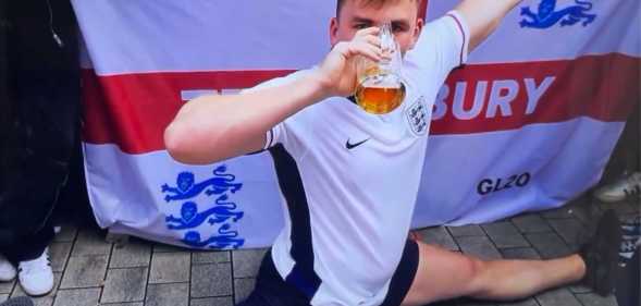 An England Euro 2024 supporter doing the splits and downing a pint