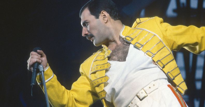 Freddie Mercury performing in his signature yelow jacket and white t-shirt.