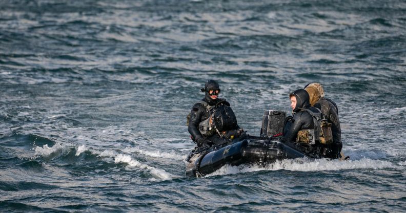 3 navy seals sitting in a boat