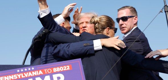 Donald Trump being saved by secret service after shots rang out at his campaign rally by shooter Thomas Matthew Crooks