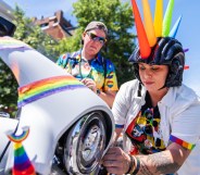 A person operating a Pride themed Harley-Davidson