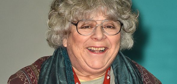 Miriam Margolyes, pictured in a pair of glasses, a scarf, and a brown top.