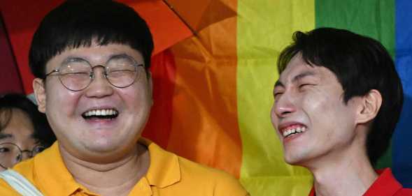 South Korean same-sex couple So Seong-wook (L) and Kim Yong-min (R) react as they speak to reporters outside the Supreme Court building in Seoul on July 18, 2024 after the court's ruling on a lawsuit against the National Health Insurance Service for their dependent family status.