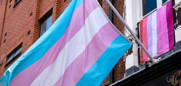 Trans flag in foreground with lesbian flag in background
