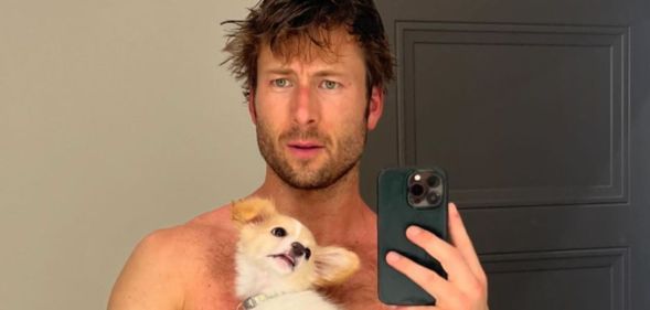 Glen Powell poses shirtless with his dog.
