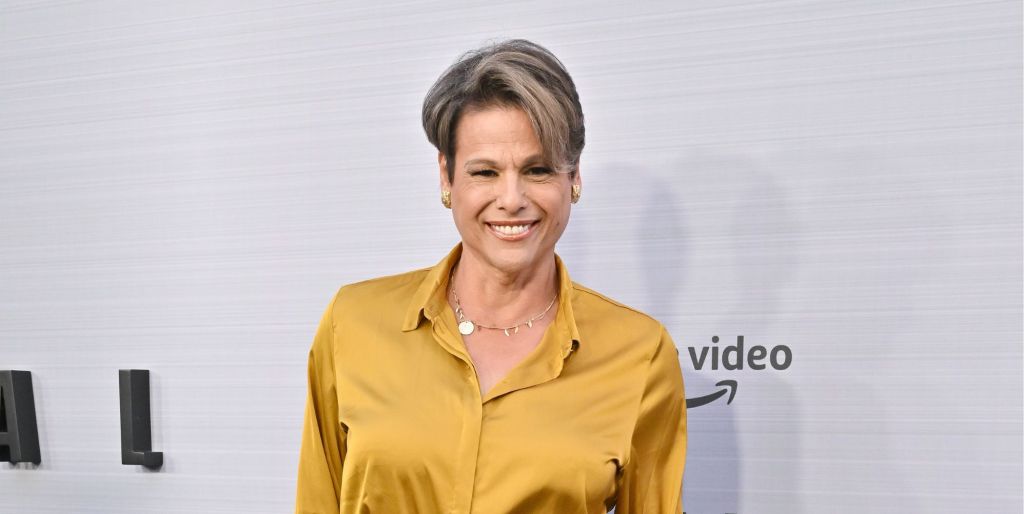 Alexandra Billings smiles in a yellow top on the red carpet.
