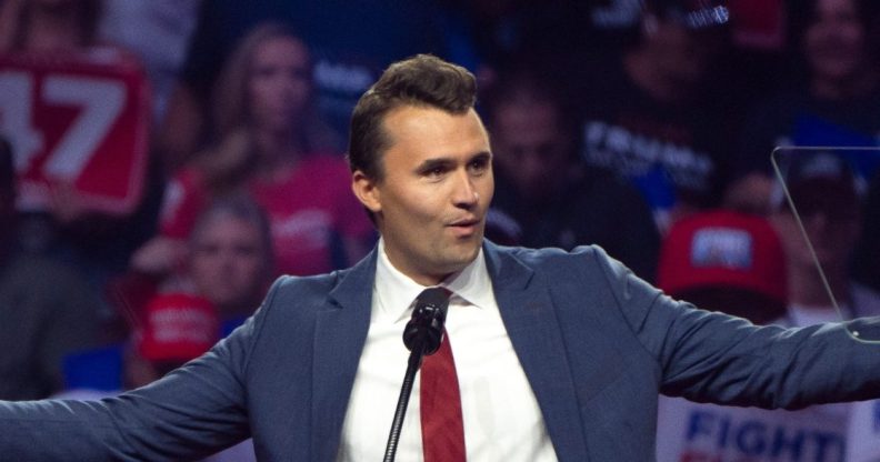 Turning Point USA Founder Charlie Kirk speaks during a campaign rally for Republican presidential nominee, former U.S. President Donald Trump, standing at the podium with his arms open