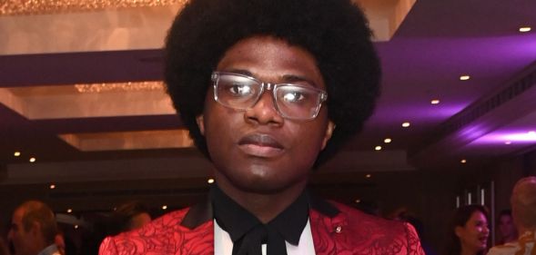 Joel Mordi during an event in a red suit.