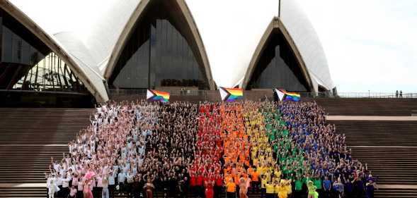 SYDNEY, AUSTRALIA - JUNE 24: 1,000 people form a human progress flag on the steps of the Opera House to mark the 44th anniversary or the Sydney Gay and Lesbian Mardis Gras Sydney Opera House on June 24, 2022 in Sydney, Australia. Australia will host WorldPride 2023. (Photo by Don Arnold/Getty Images)