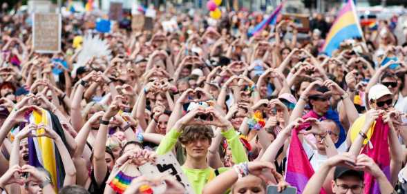 Attendees of Leipzig Pride hold up a heart symbol as they participate in the Pride rally.