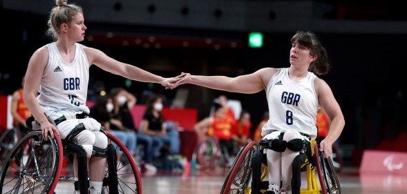 Britain's Robyn Love and her partner Laurie Williams touch hands in the wheelchair basketball women's classification playoff