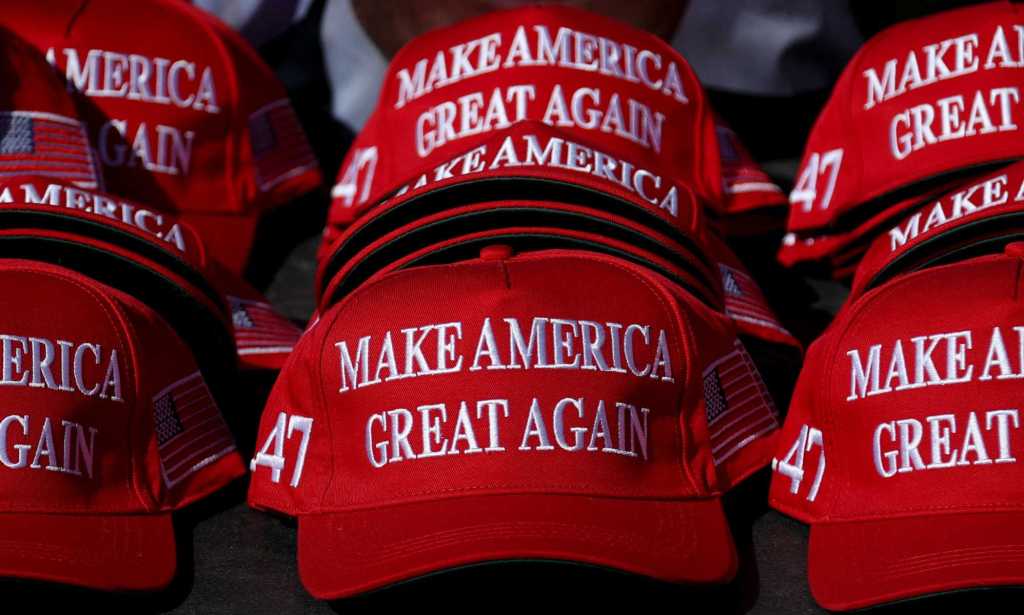 "Make America Great Again" hats sit on a table during a campaign rally for former US President and Republican presidential candidate Donald Trump.