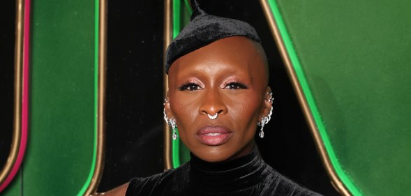 Cynthia Erivo attends the "Wicked: Part One" European Premiere . wearing dark green velvet dress and hat with multiple silver earings.