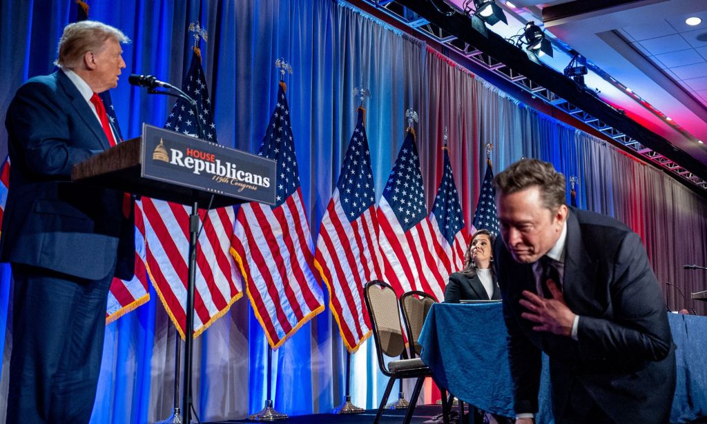 Elon Musk walking under a conference with Donald Trump