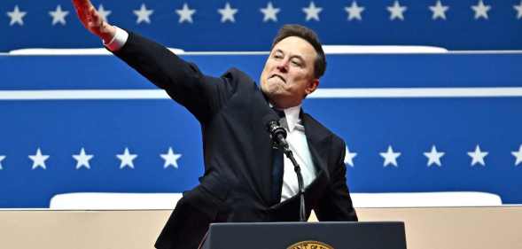 Elon Musk lifting his arm in the air