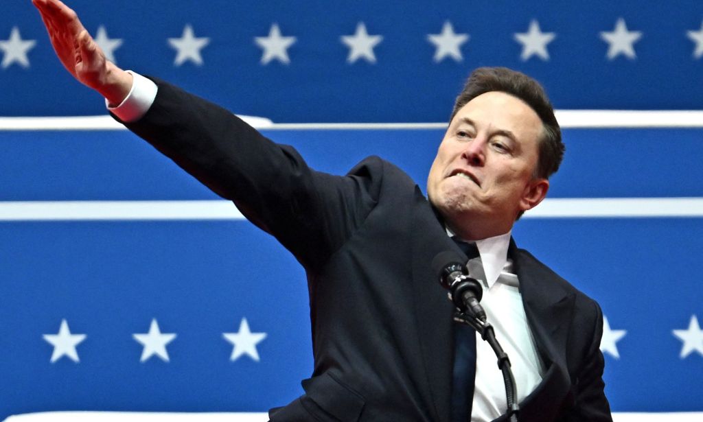 Elon Musk giving a salute to a crowd.