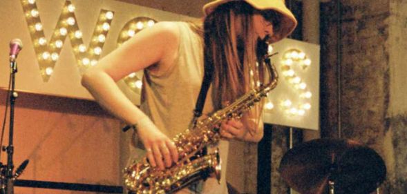 A person playing the saxophone on stage.
