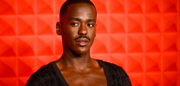 Photo of Doctor Who star Ncuti Gatwa in front of a red background