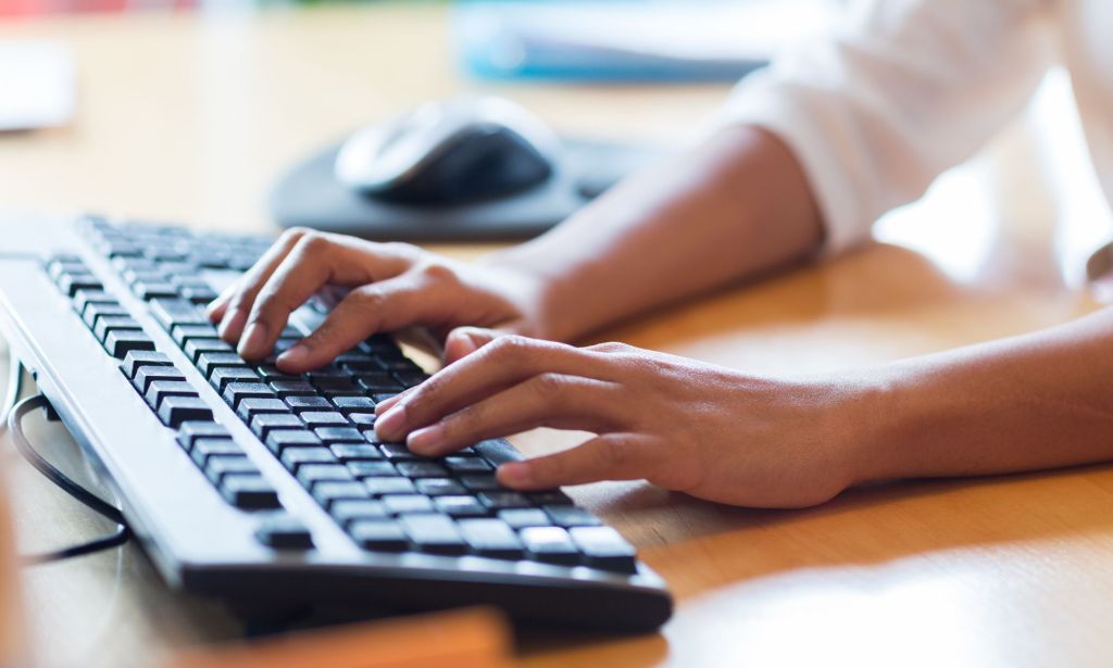 A person typing on a keyboard.
