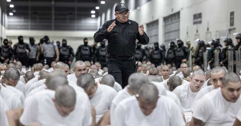 In this handout photo provided by the Salvadoran government, a guard gives directions to the inmates allegedly linked to criminal organisations at CECOT.