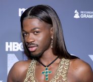 Lil Nas X poses on a red carpet in 2024.