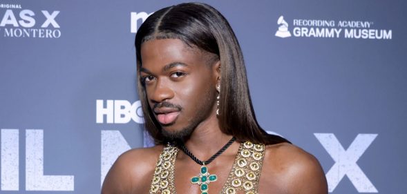 Lil Nas X poses on a red carpet in 2024.