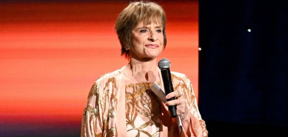 Patti LuPone stands smiling with a microphone at the GLAAD Media Awards