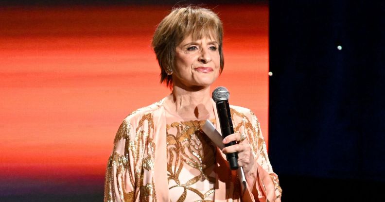 Patti LuPone stands smiling with a microphone at the GLAAD Media Awards