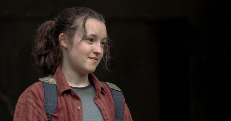 Bella Ramsey in a red shirt and wearing a backpack in role as Ellie in The Last of Us
