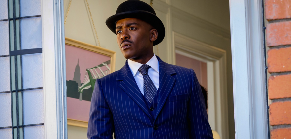 Ncuti Gatwa in a blue suit and tie and hat combo in a Doctor Who promo photo.