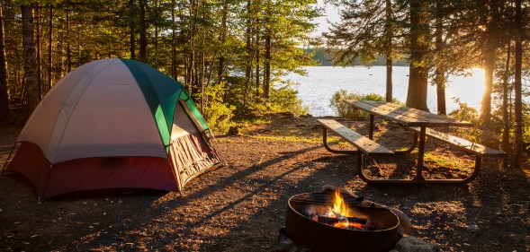 Campsite on lake in northern Minnesota with campfire at sunset