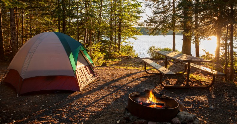 Campsite on lake in northern Minnesota with campfire at sunset