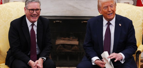 UK Prime Minister Sir Keir Starmer hands an invitation from King Charles III for a second state visit to U.S. President Donald Trump at the White House.