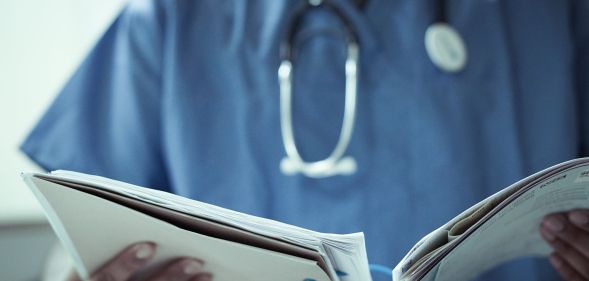 A doctor looking at two files.