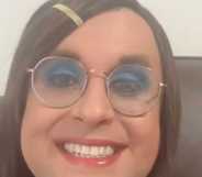 Trans teacher Rosie Sandri smiles widely at the camera.