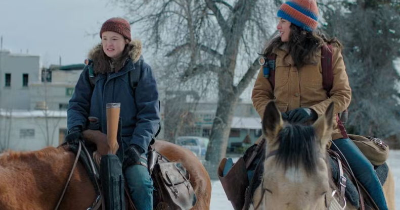 Ellie and Dina from The Last of Us ride horses across a snowy landscape