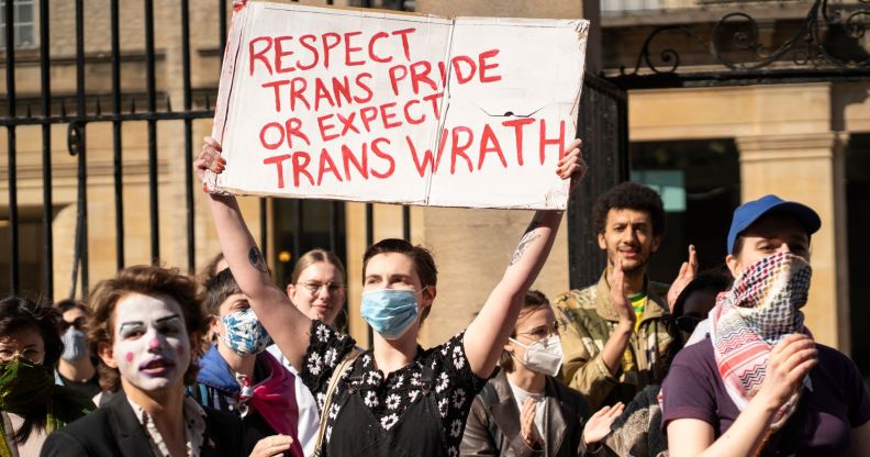 Protester holds up sign reading "Respect trans pride or expect trans wrath"