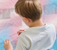 A pupil in a classroom with a trans-themed graphic.