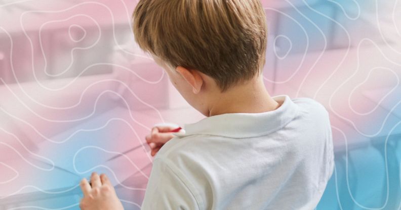 A pupil in a classroom with a trans-themed graphic.