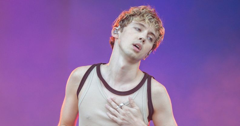 Troye Sivan holds his chest as he performances at Primavera Sounds 2024 in a vest top.