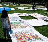 An individual looking at the ACLU trans quilt.